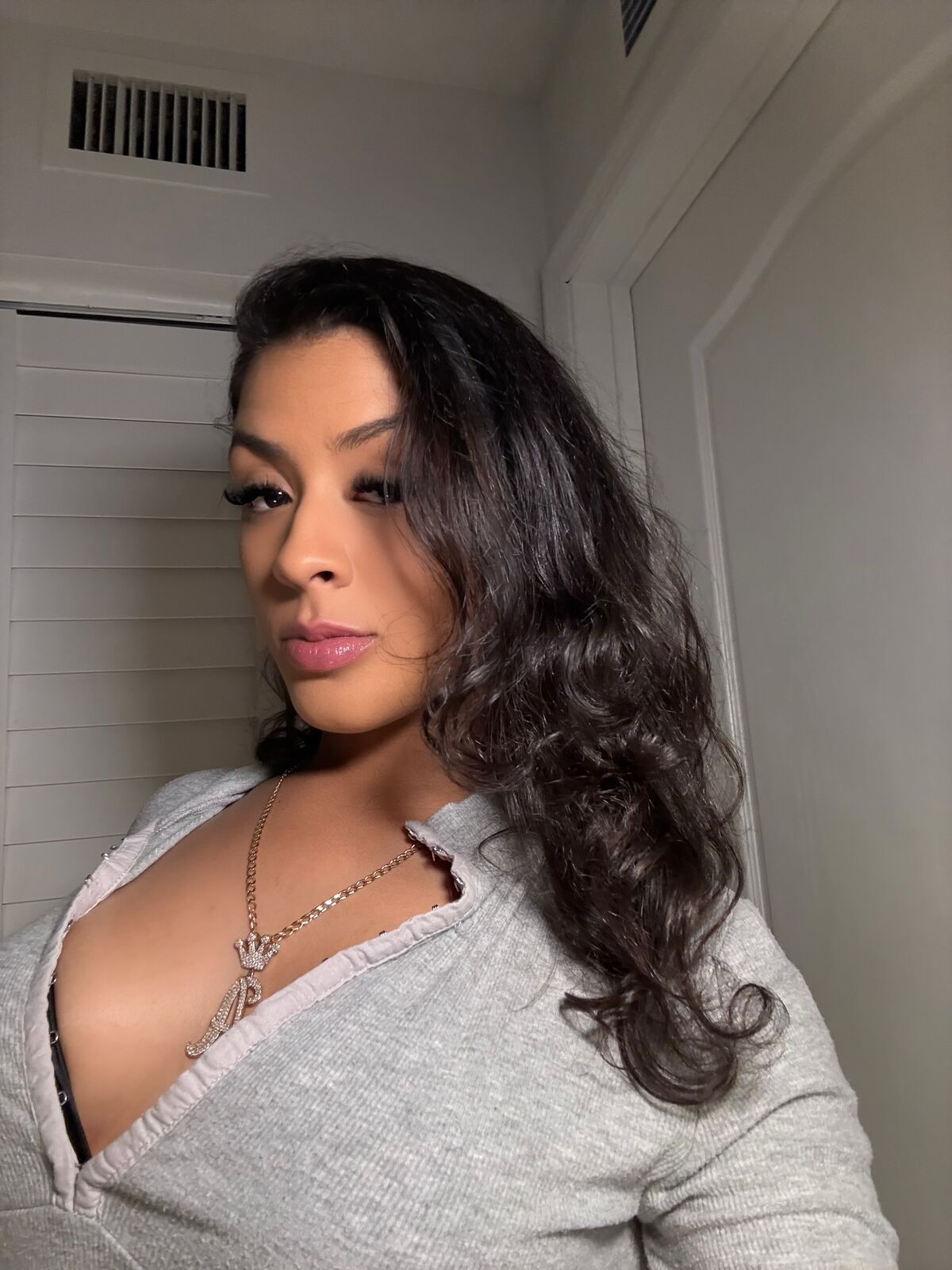 Selfie of LA Real Ash with long dark wavy hair, grey henley top and necklace